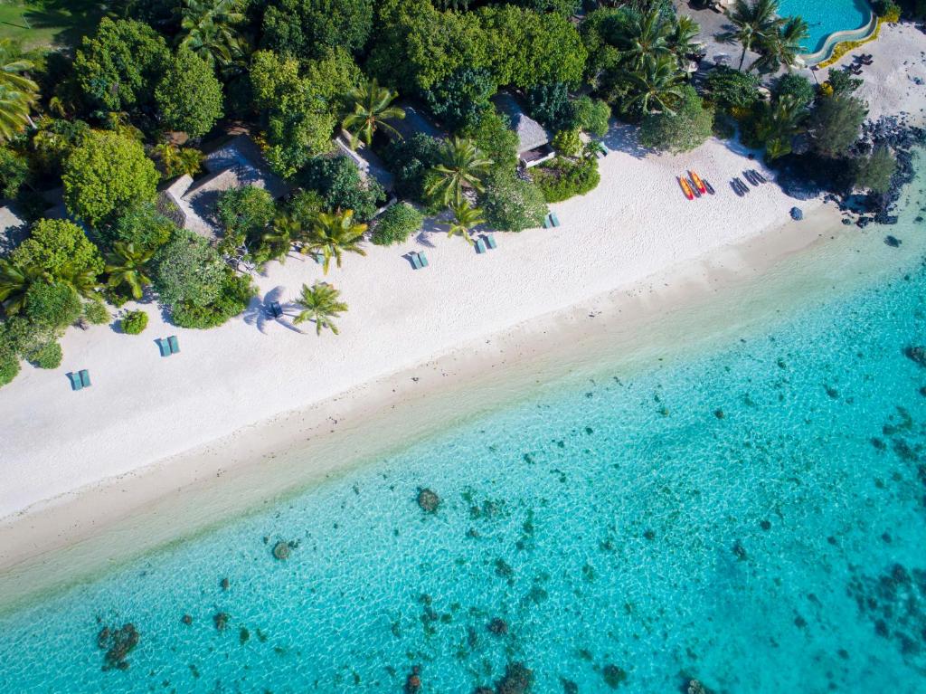 an overhead view of a beach with chairs and the ocean at Pacific Resort Aitutaki - Adults Only in Arutanga