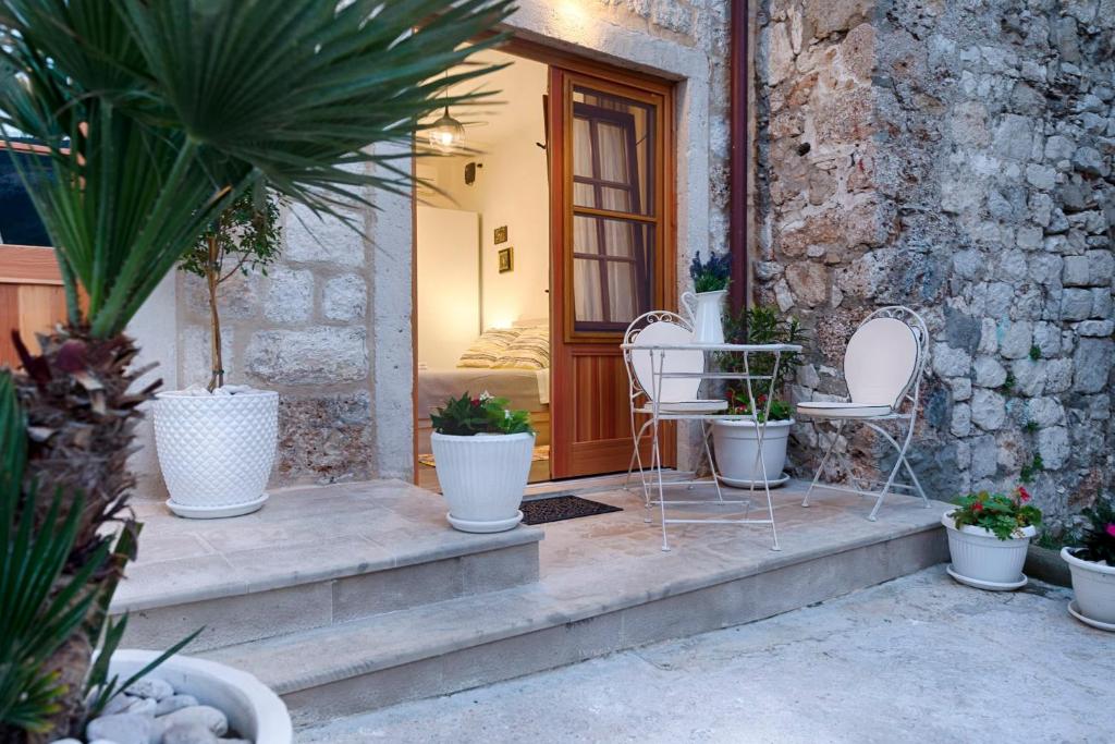 un portico con due sedie e un tavolo con piante di En Suite Room Demaria a Komiža