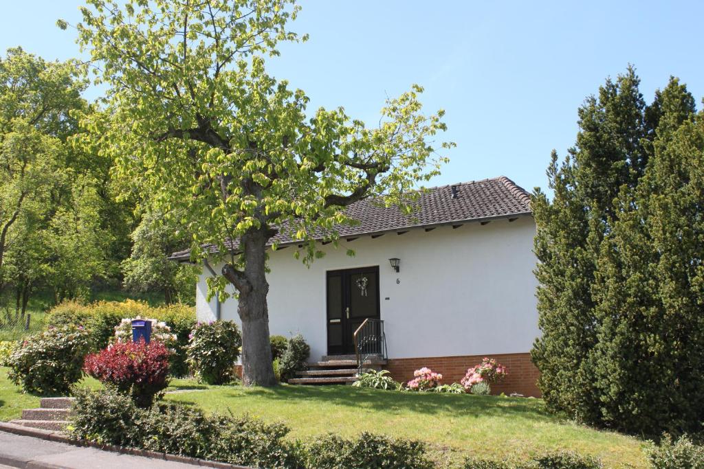 a white house with a tree in the yard at Ferienhaus Rosental in Wanfried