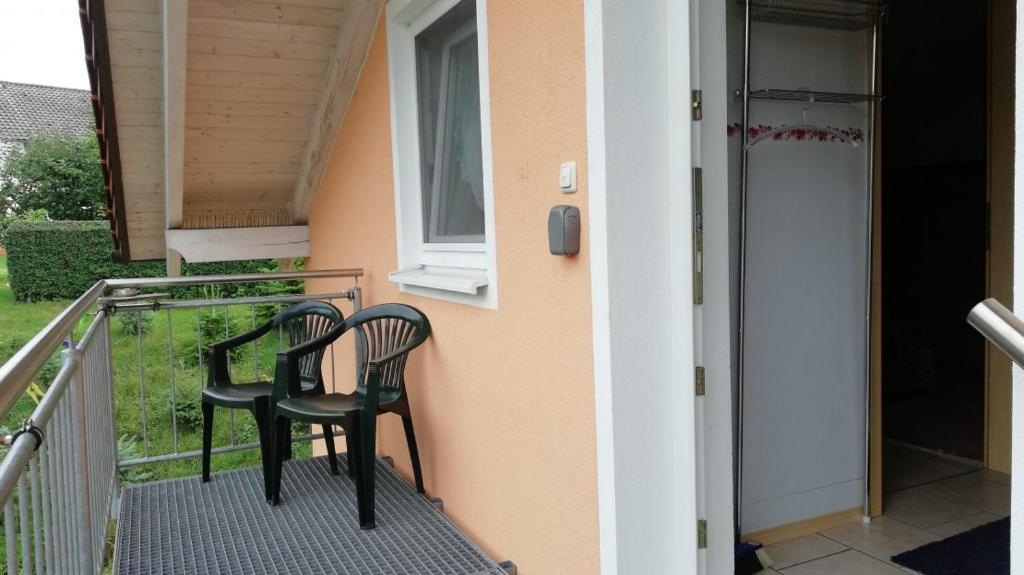 twee stoelen op het balkon van een huis bij Stadldorf» Ferienwohnung Wagner in Kirchroth