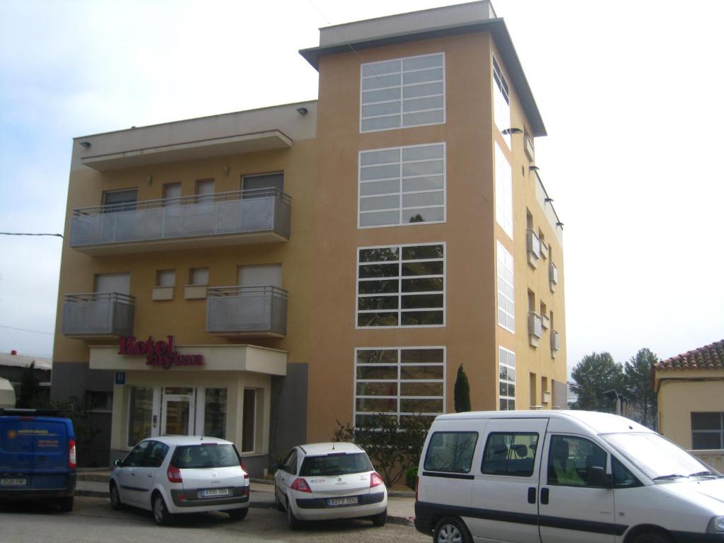 two cars parked in front of a building at Hotel Zaytun in Mequinenza