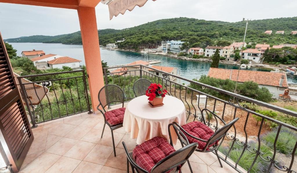 einen Balkon mit einem Tisch und Stühlen sowie Blick auf das Wasser in der Unterkunft Apartment Ivan - sea view & serenity in Božava