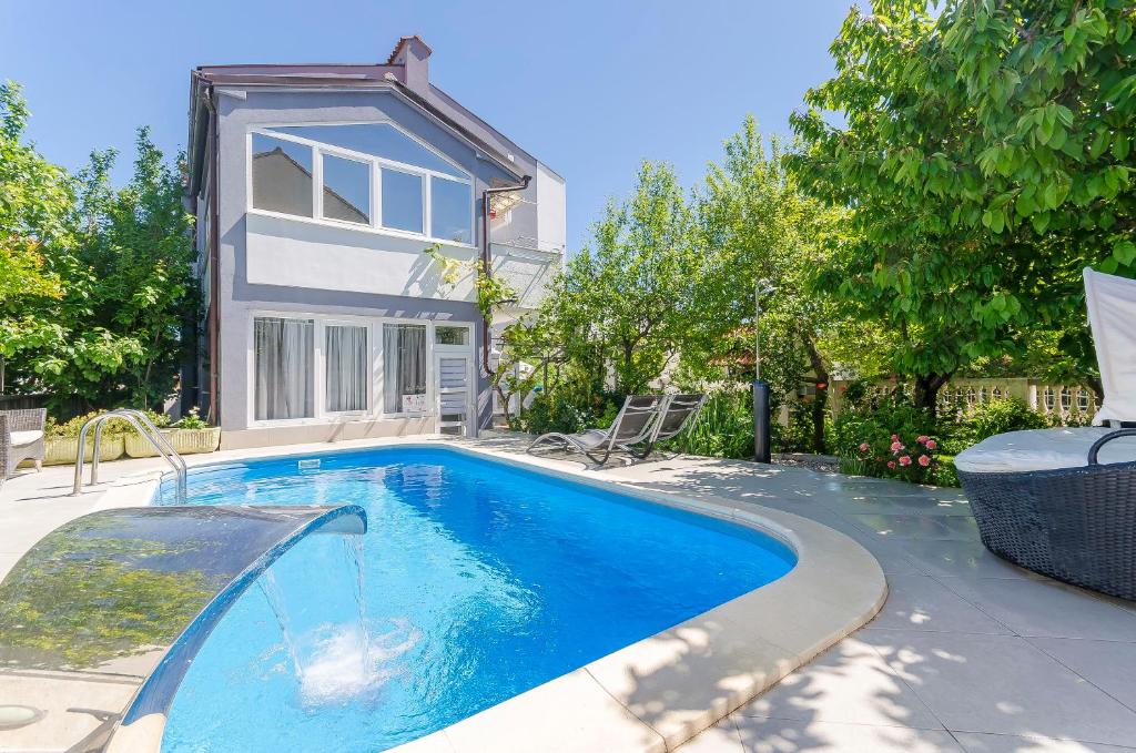 ein Swimmingpool vor einem Haus in der Unterkunft Apartment Ljubica in Vodice