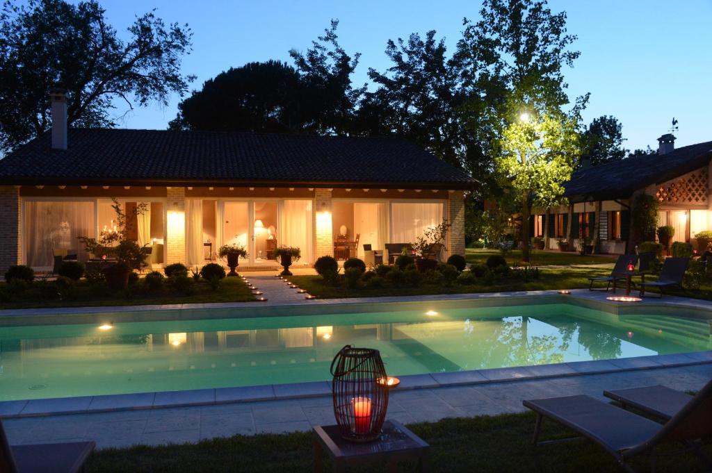 a swimming pool in front of a house at night at A Casa Di Delia B&B Charming House in Sant'Elena di Silea