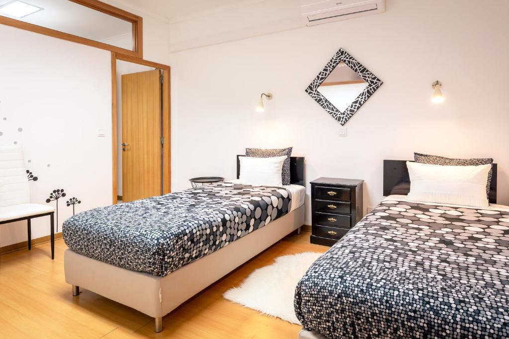 a bedroom with two beds and a mirror at Rocky3 in Angra do Heroísmo