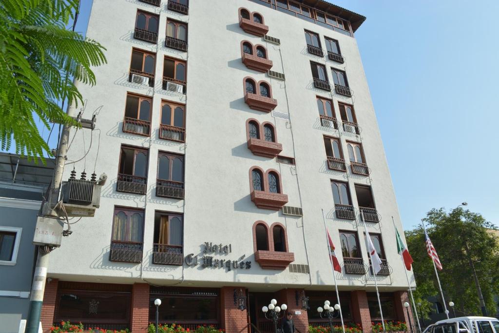 - un grand bâtiment blanc avec des fenêtres et des balcons dans l'établissement Hotel El Marqués, à Lima