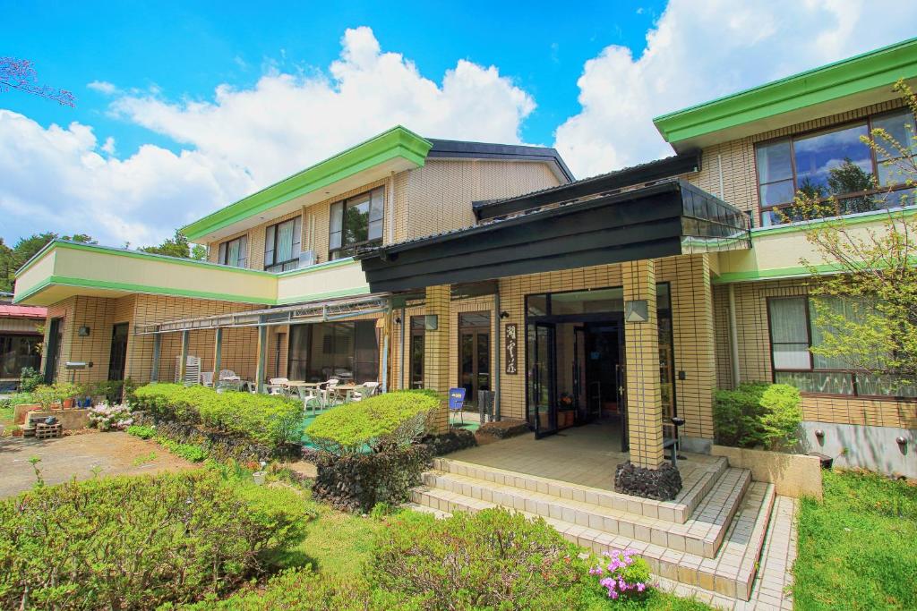 a large house with a porch and a yard at Kounso in Yamanakako