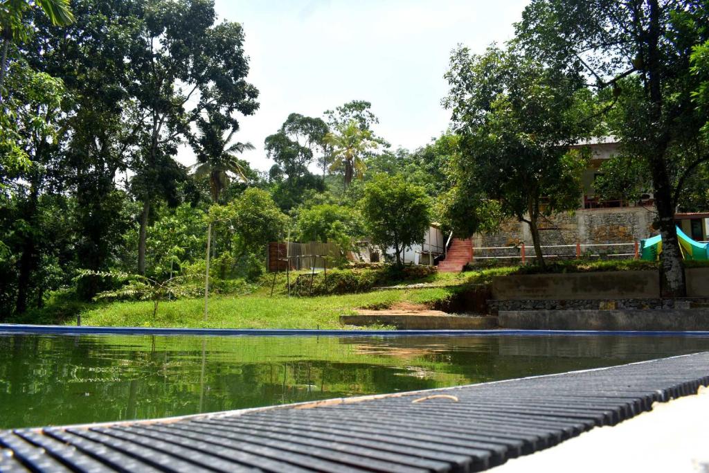 una piscina de agua con un edificio al fondo en Ella Residence Eco Resort, en Padukka