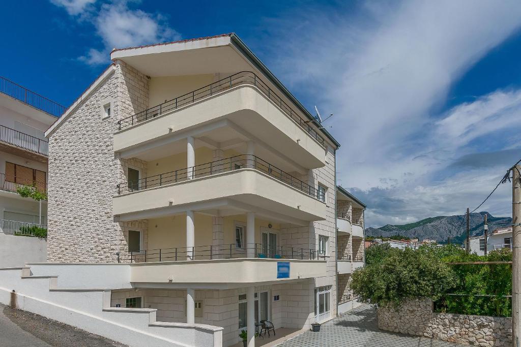 un edificio blanco con balcones en un lateral en Apartments Villa Aquamarine, en Duće