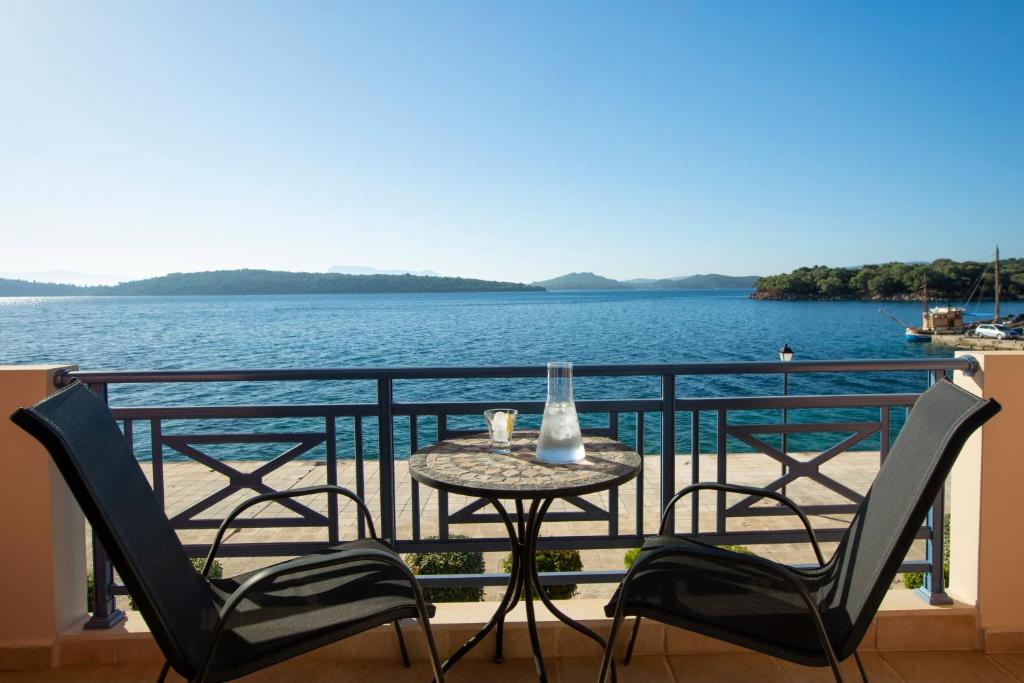 a table and chairs on a balcony with a view of the water at Thalassa Apartments in Nydri