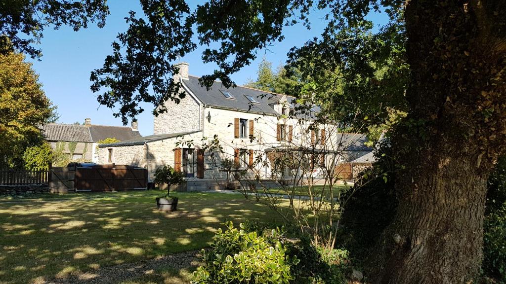 una casa blanca con un árbol en el patio en le jardin des chênes, en Plumelec