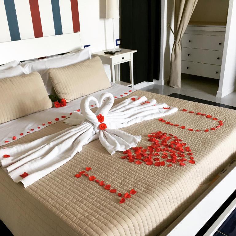 a bed with a bunch of red roses on it at Casamediterranea in Sperlonga