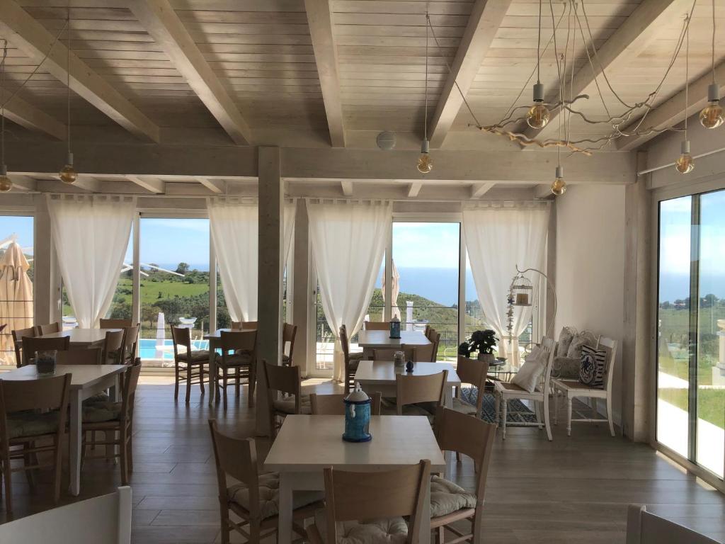 a restaurant with tables and chairs and large windows at Casamediterranea in Sperlonga