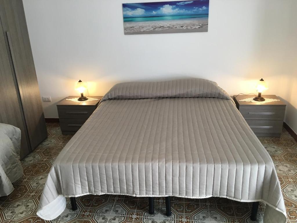 1 cama en un dormitorio con 2 mesitas de noche y 2 lámparas en Al Chiaro Di Luna, en Taormina