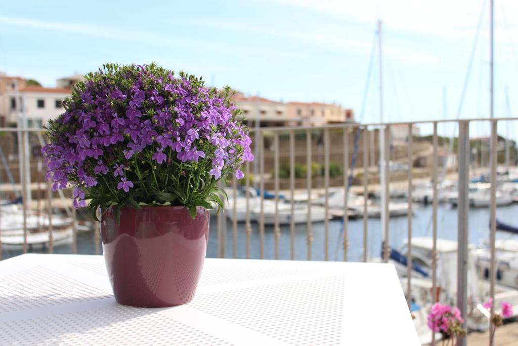 a vase filled with purple flowers sitting on a table at 103 Boutique Hotel Stintino in Stintino