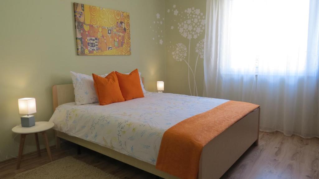 a bedroom with a bed with orange pillows and a window at Pineta25 in Pula