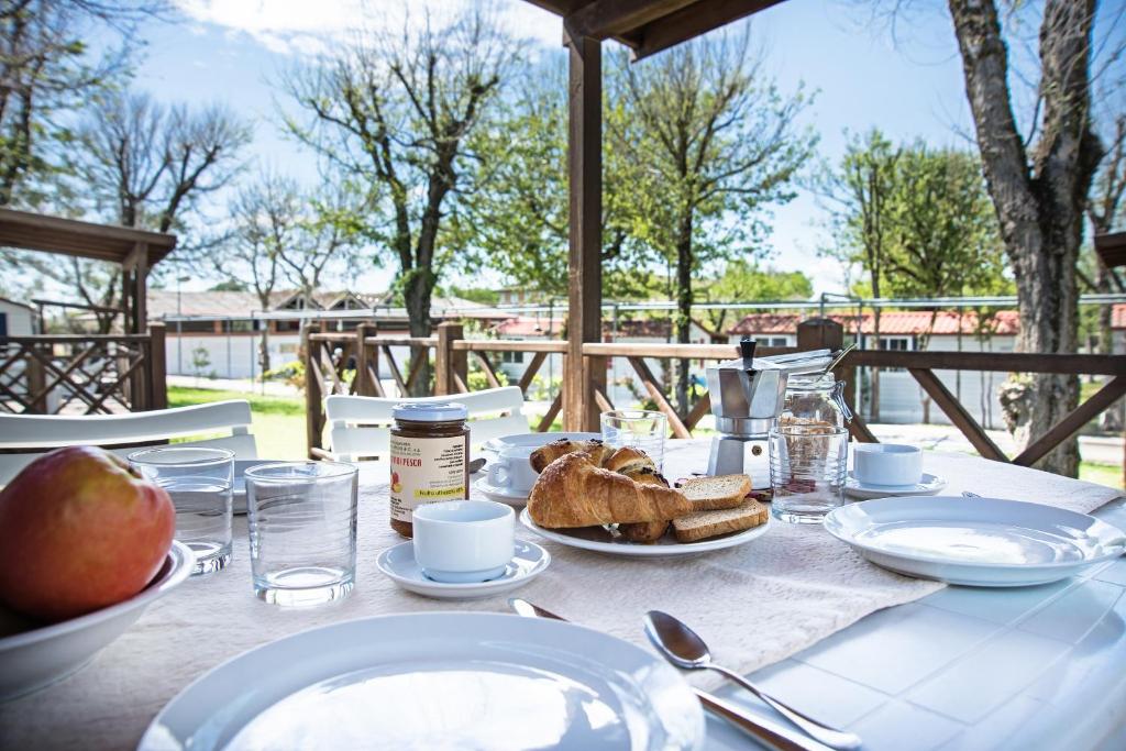 a table with a plate of food and bread on it at Villaggio San Francesco in Duna Verde