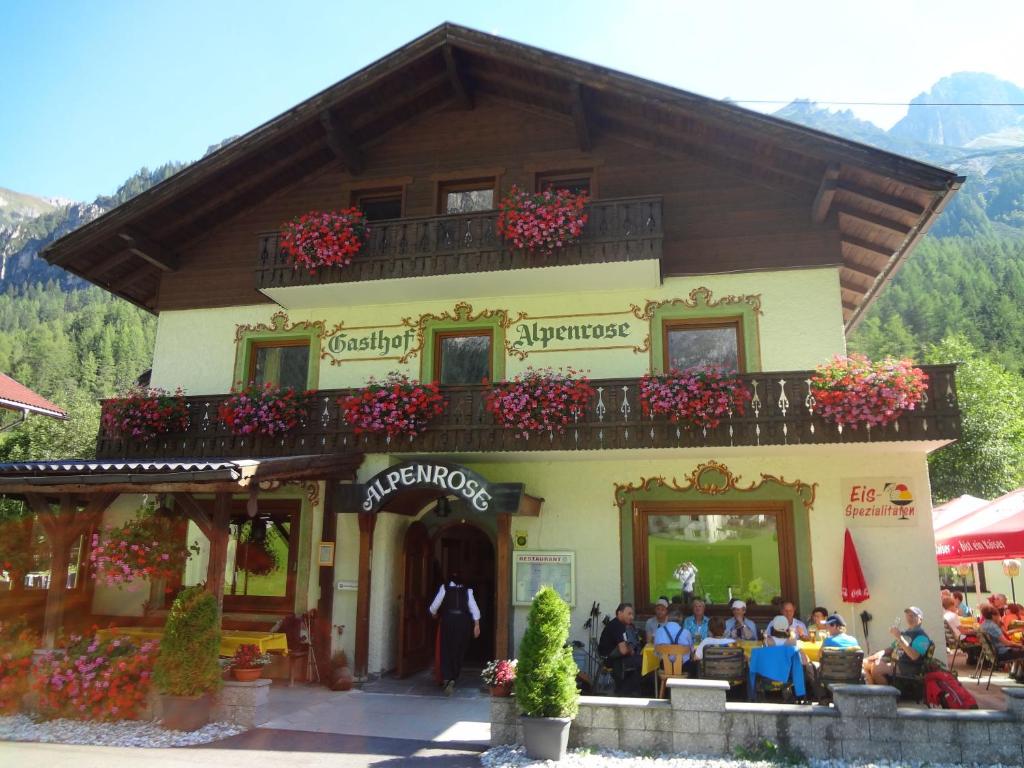 a group of people sitting outside of a building at Gasthof Alpenrose und Pension Nina in Gschnitz