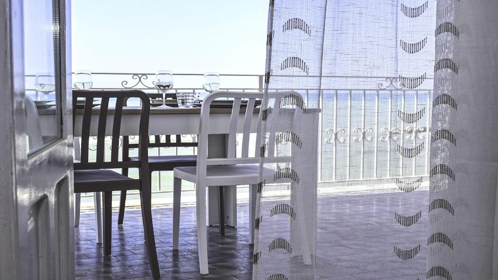 d'une salle à manger avec une table, des chaises et une fenêtre. dans l'établissement Terrazza sul Mediterraneo, à Seccagrande