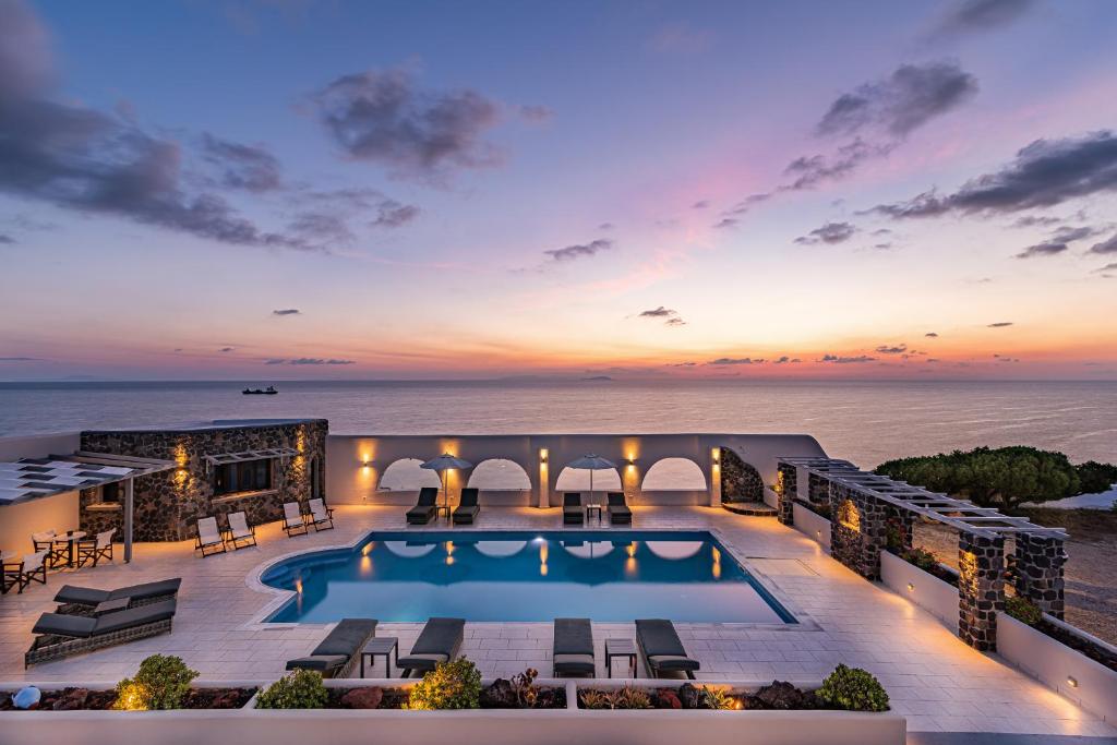 an aerial view of a resort with a pool and the ocean at Agia Irini in Imerovigli