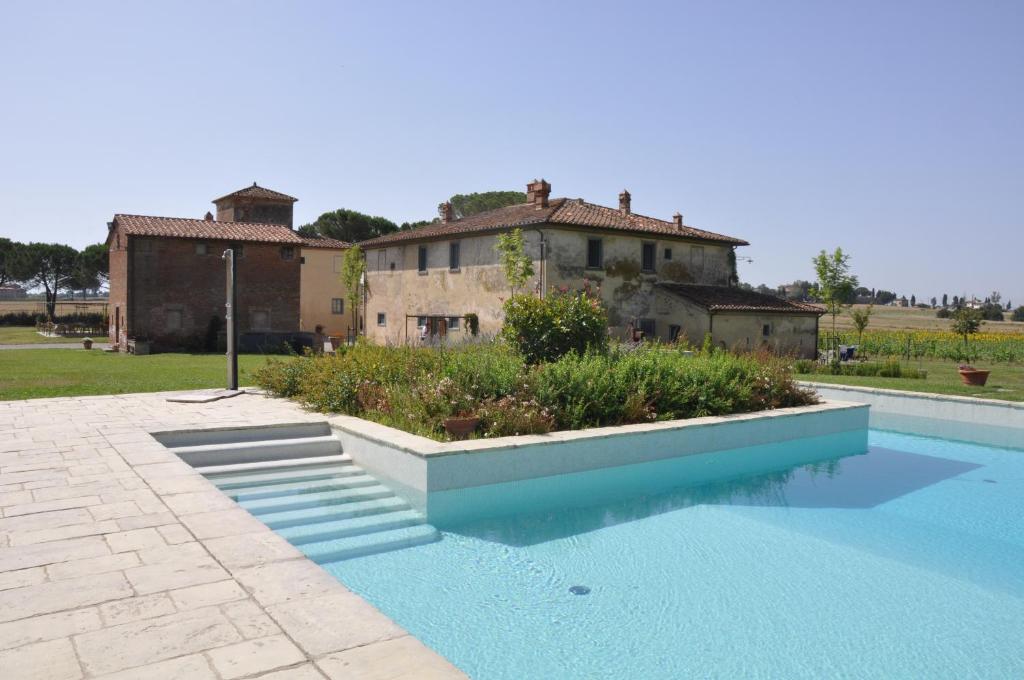 ein Schwimmbad mit einem Haus im Hintergrund in der Unterkunft Cortona Resort-Le Terre Dei Cavalieri in Cortona