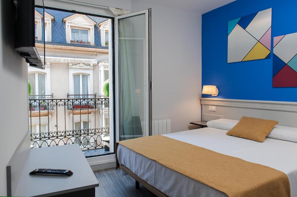um quarto de hotel com uma cama e uma varanda em Hotel Hito em Vitoria-Gasteiz