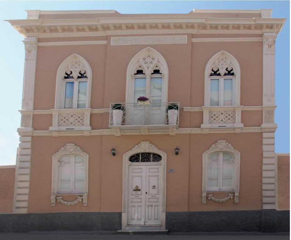 a pink building with two windows and a door at La Peonia Charming Accommodation in Cagliari