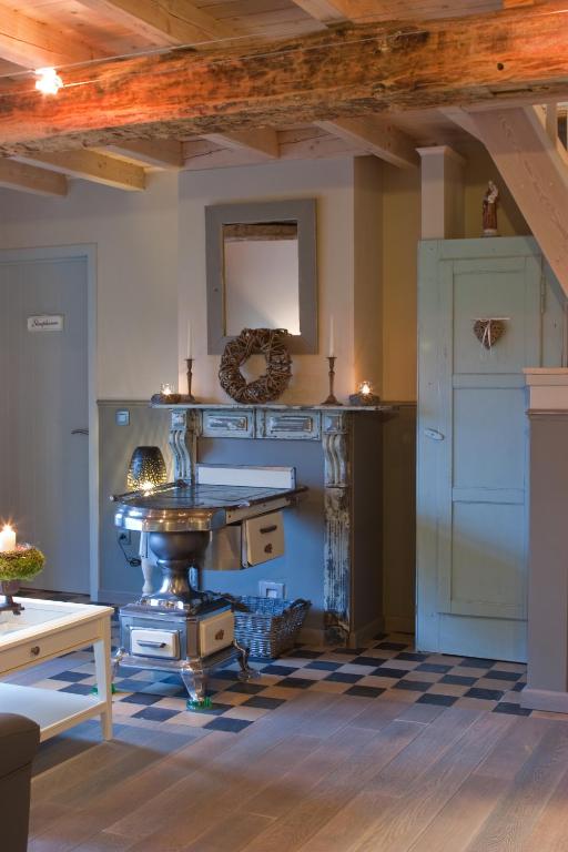 a kitchen with a counter and a table in a room at Bij de Zöster in Kinrooi