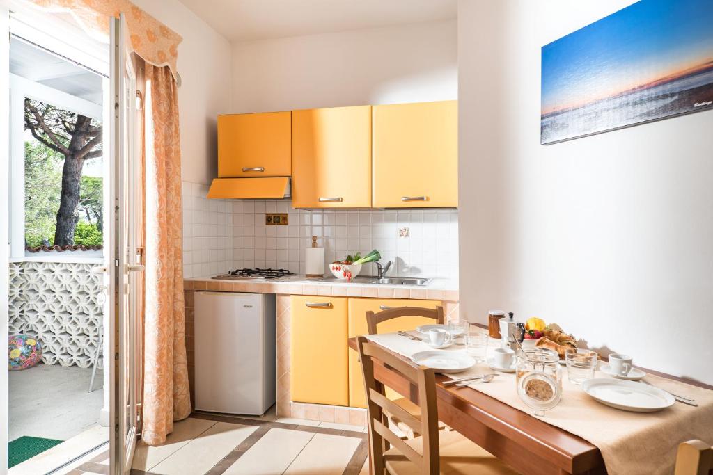 a kitchen with a wooden table and yellow cabinets at Villaggio San Francesco in Duna Verde