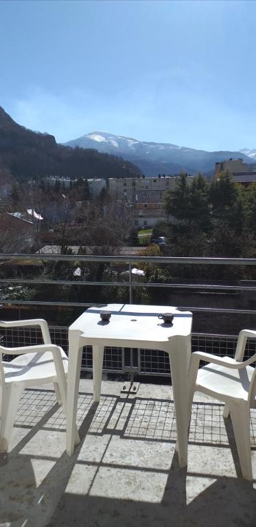 une table blanche et deux chaises sur le toit dans l'établissement Lourdes Pyrénées, à Lourdes