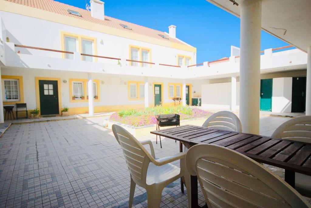 d'une terrasse avec une table en bois et des chaises blanches. dans l'établissement Casa Paulo - Baleal beach, Terrace, à Baleal