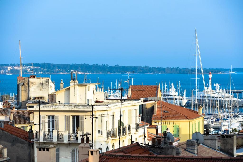 een uitzicht op een stad met een haven en een boot bij appartement vue mer in Cannes