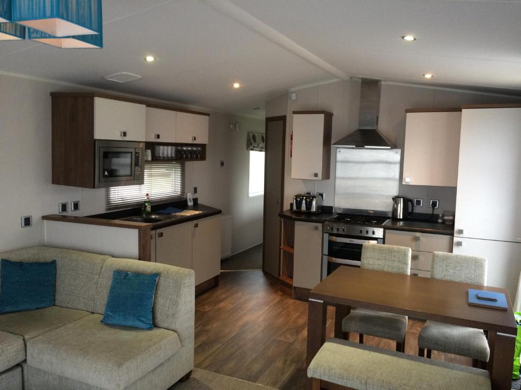 uma cozinha e sala de estar com um sofá e uma mesa em Silver Woods Reighton Sands em Filey