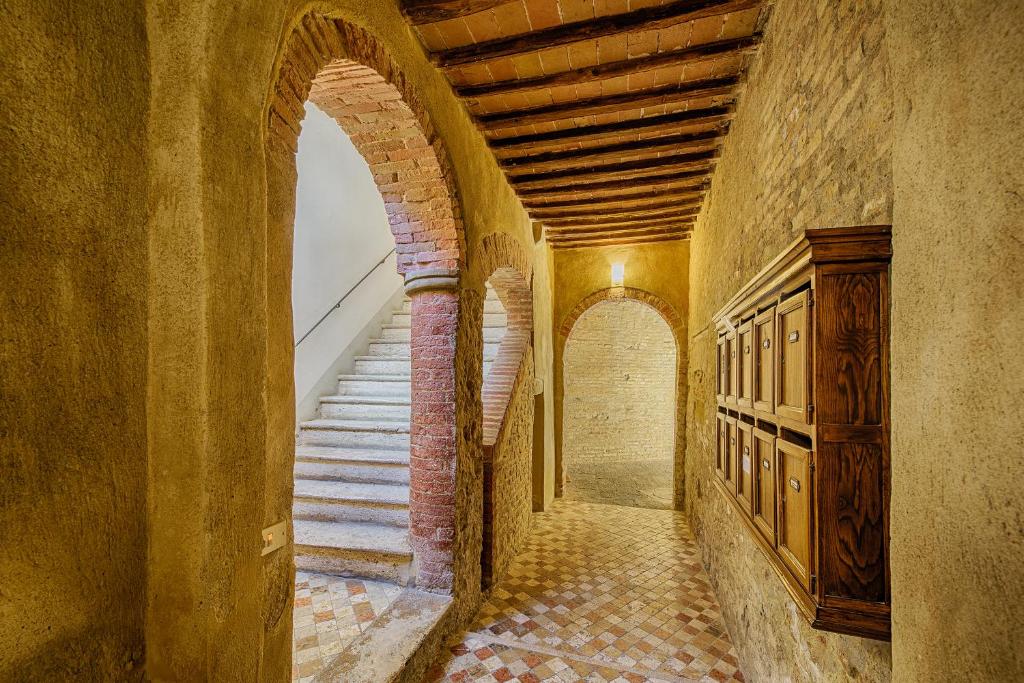 un couloir vide avec des escaliers dans un ancien bâtiment dans l'établissement Ele Home, à Sienne