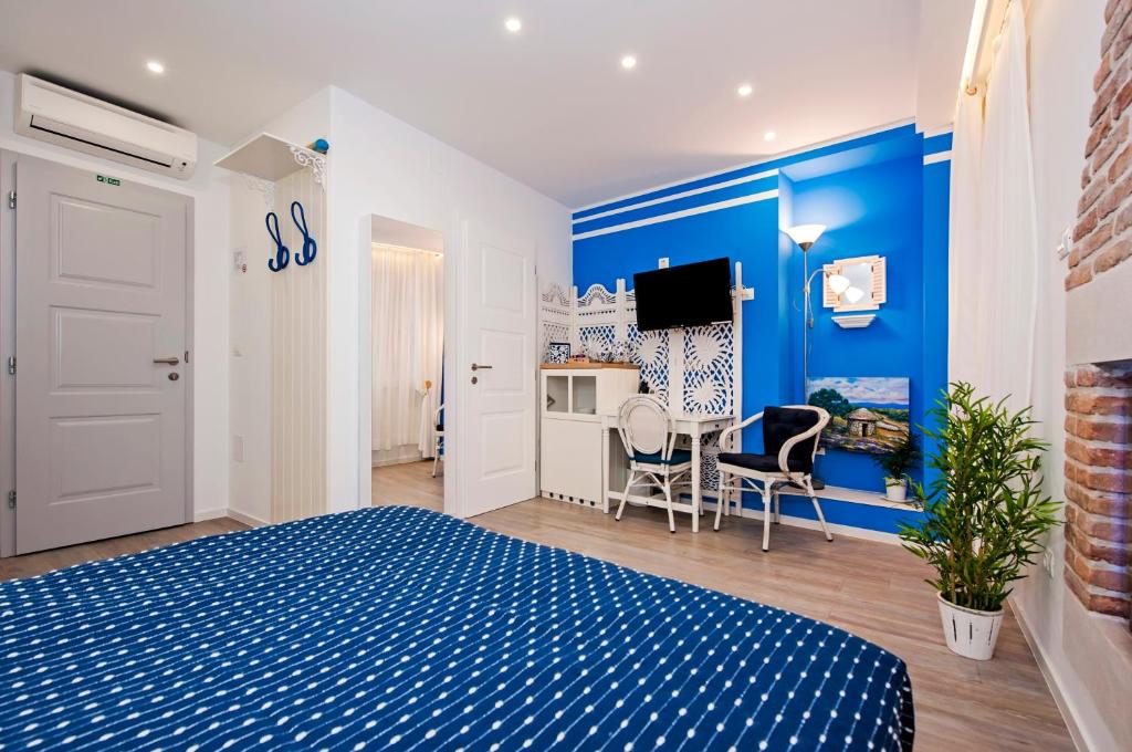 um quarto azul e branco com uma cama e uma mesa em Santa Lucia Guest House em Rovinj