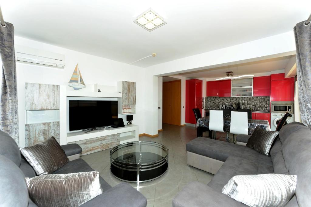 a living room with a couch and a tv and a table at Exclusive Luxury Apartments in Oceano Atlantico Complex in Portimão