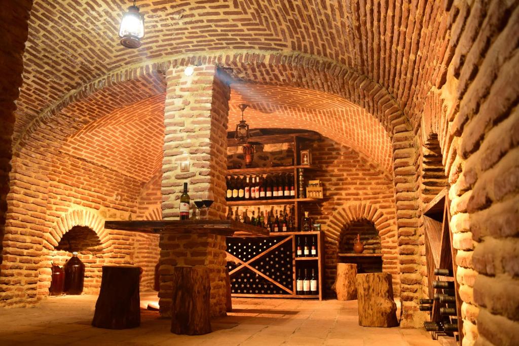 une cave à vin avec une table dans un mur de briques dans l'établissement Guest House Eka & Gio, à Sighnaghi