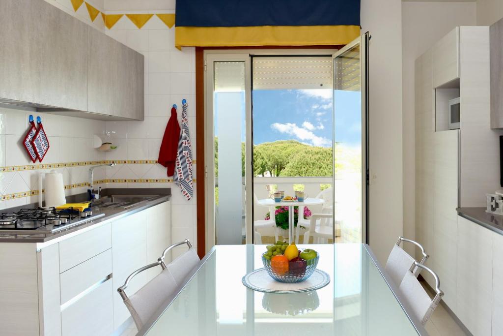 eine Küche mit einem Tisch und einer Obstschale darauf in der Unterkunft Condominio Al Cigno in Lignano Sabbiadoro