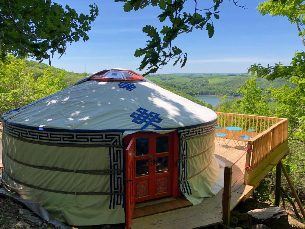 a yurt with a deck and a view of a lake at Yourte Mongole in Mont-Roc