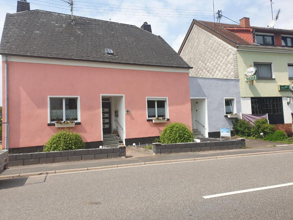 uma casa cor-de-rosa ao lado de uma rua em Ferienwohnung Müller em Wadern
