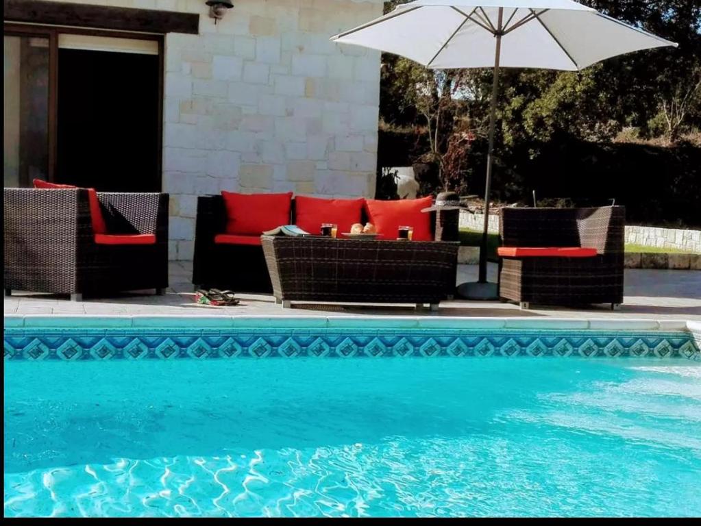 una piscina con sedie e ombrellone accanto a una piscina di Lasa Valley Villa a Lasa