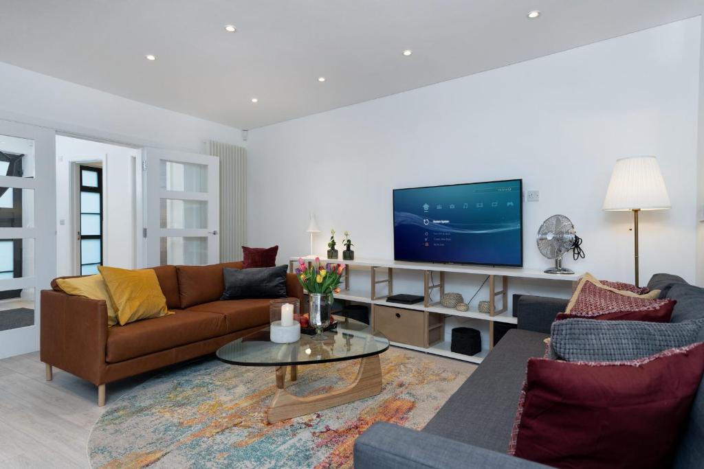 ein Wohnzimmer mit einem Sofa und einem TV in der Unterkunft Huge & Central 3 Bedr, 4 Beds, 2,5 Bath Covent Gdn in London