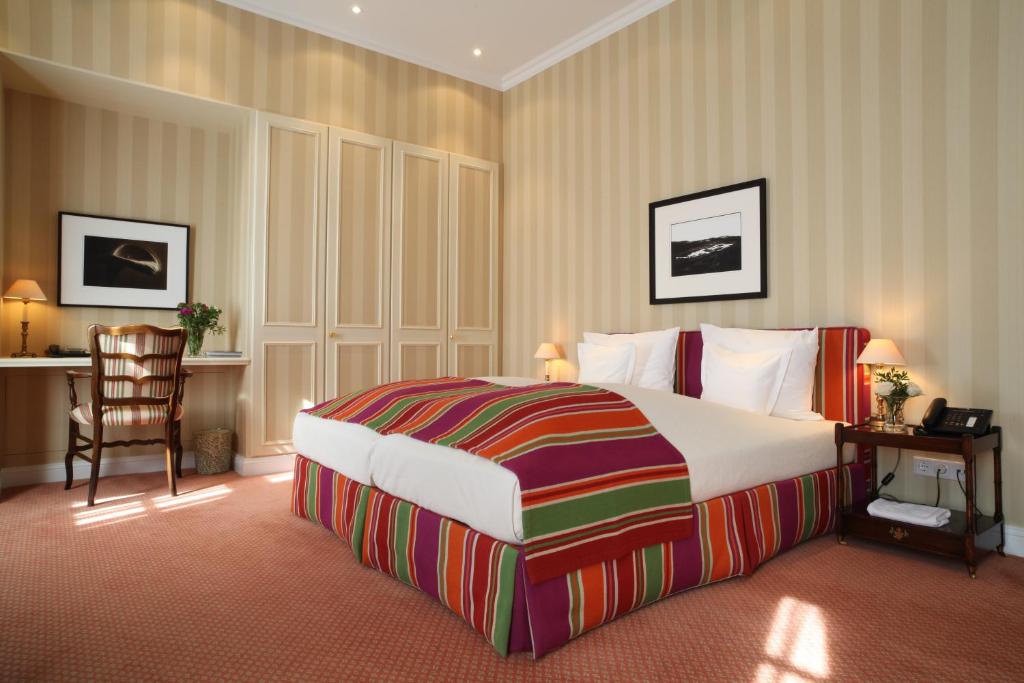 a hotel room with a large bed and a desk at Hotel Stadt Hamburg in Westerland