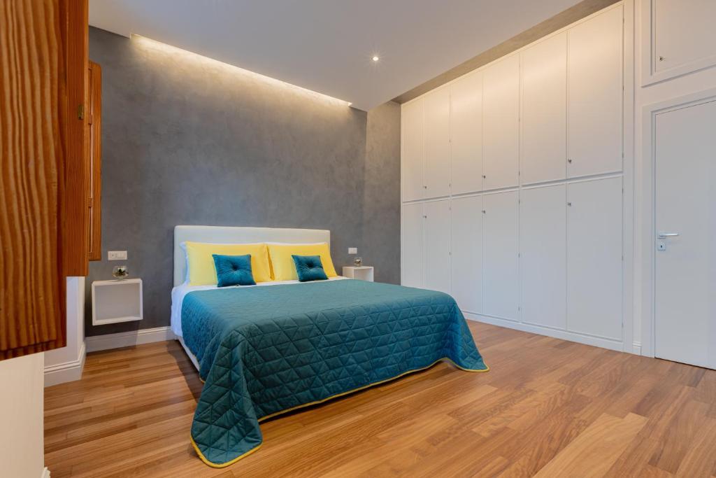 - une chambre avec un lit doté d'oreillers bleus et jaunes dans l'établissement Marcus Suite, à Cagliari