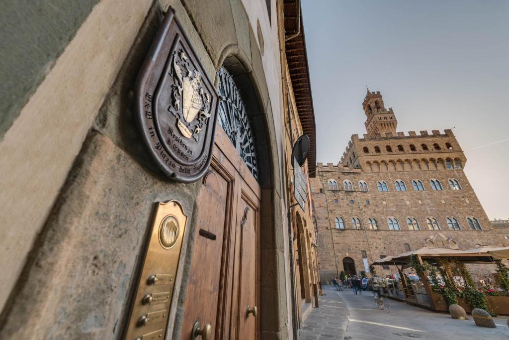 un orologio sul lato di un edificio di Residenza D'Epoca In Piazza della Signoria a Firenze