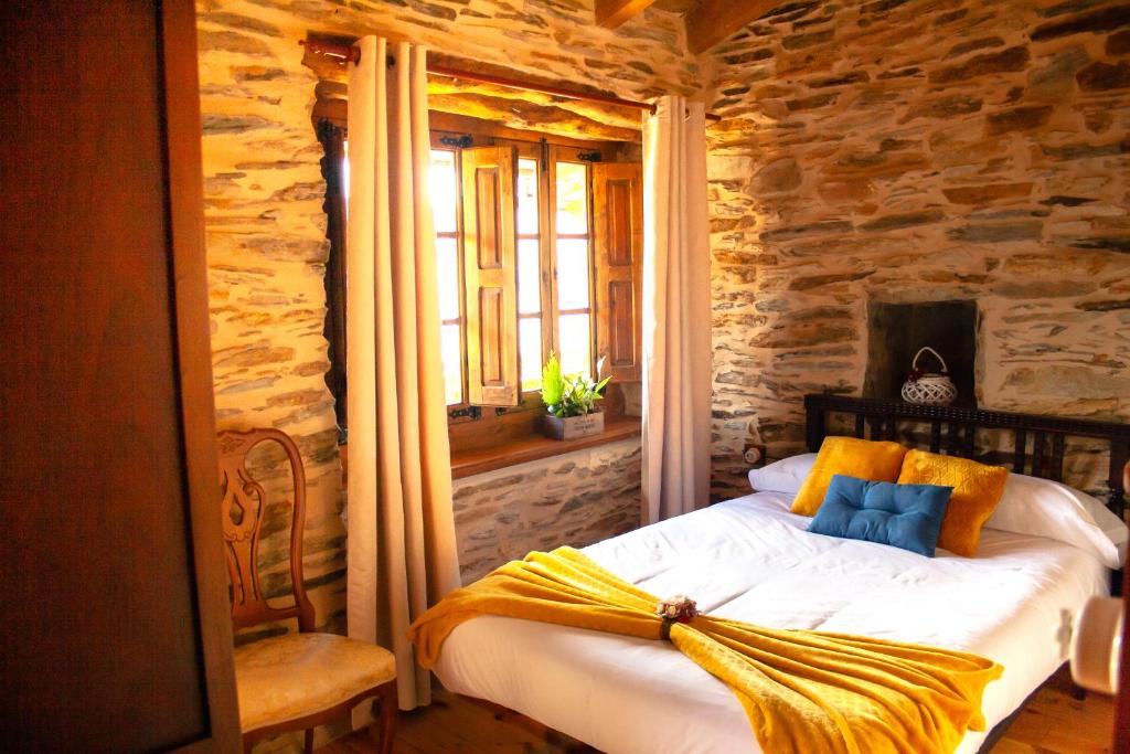 Un dormitorio con una cama con una manta amarilla. en CASA RURAL BIERZO ENCANTADO, en Valle de Finolledo