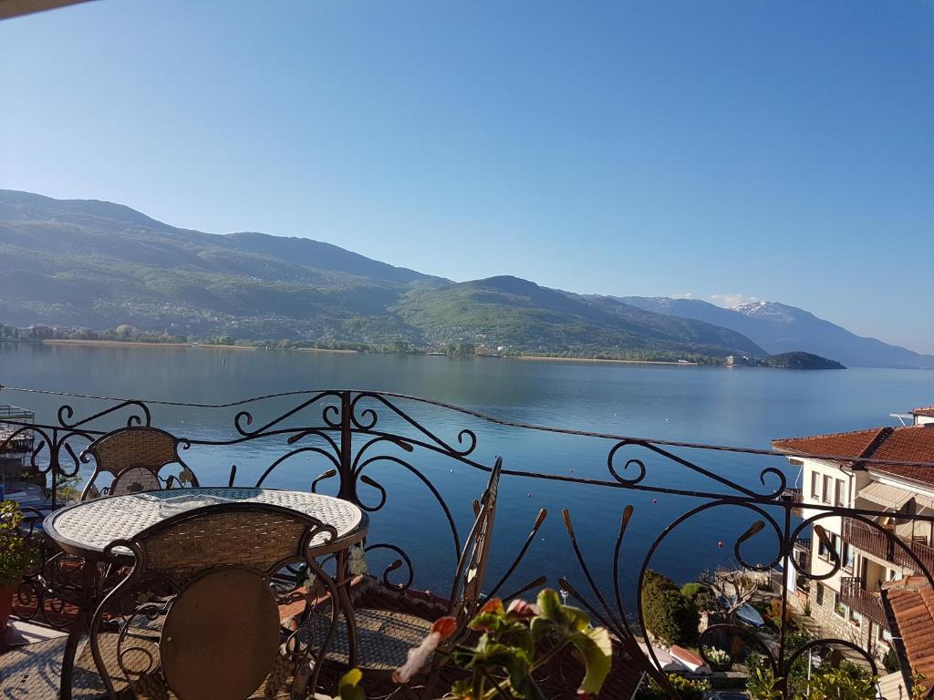 balcón con mesa y sillas y vistas al lago en Casa Germanoff, en Ohrid