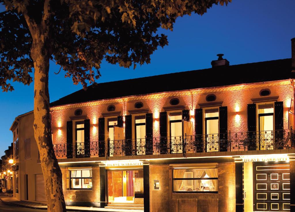 an old building with lights on it at night at Villa MARSAN - Maison Hervé-Martin GARRAPIT in Villeneuve-de-Marsan