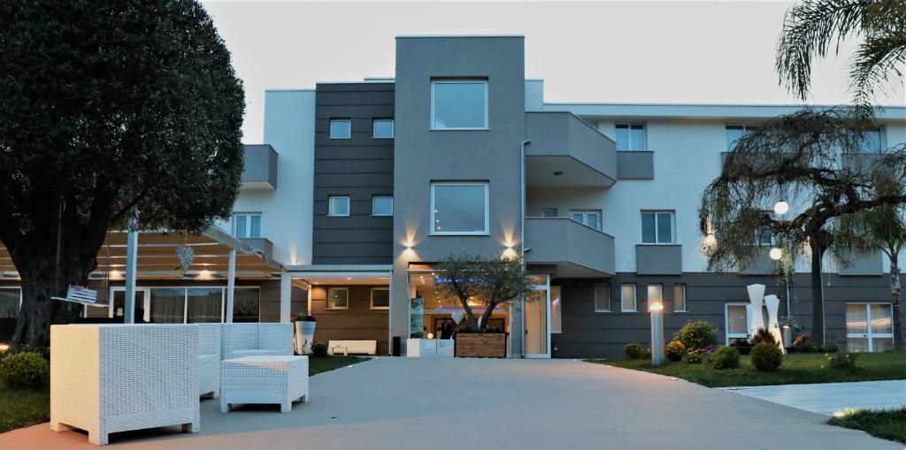 un bâtiment avec des meubles blancs devant lui dans l'établissement Medea Resort, à Bellona