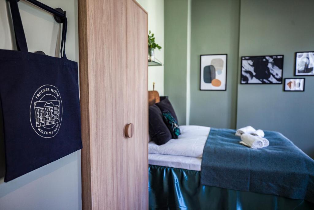 een slaapkamer met een bed met een blauwe deken bij Frogner House - Nationaltheatret in Oslo